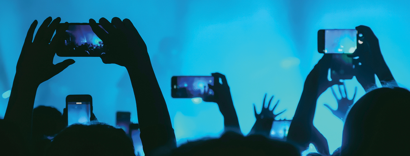 hands holding up cellphones during a concert