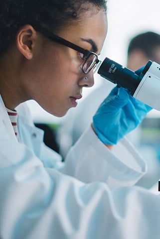 A scientist looking into a microscope