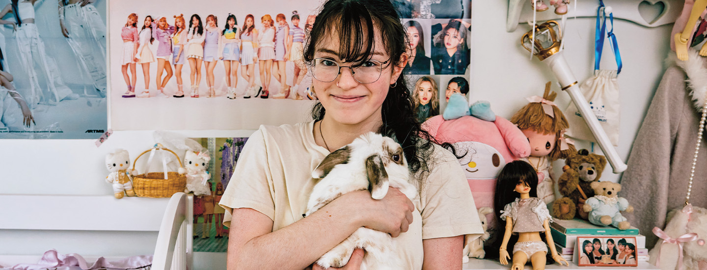 Photo of a teen posing with her bunny while in her room