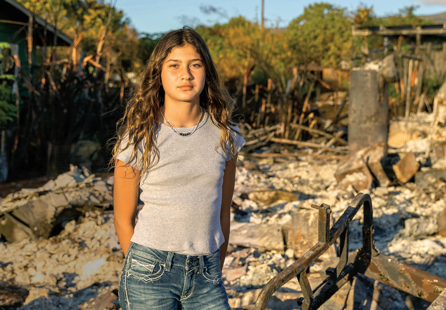 Image of a teen posing in front of a destroyed building