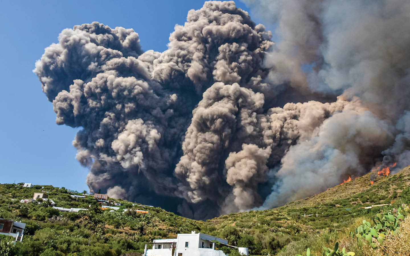 Photo of large clouds of black smoke erupting from a volcano